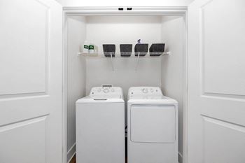 a washer and dryer in a laundry room with white walls and white doors
